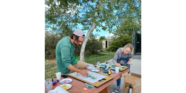 Volunteers Michael Galano and Yvonne Jongeling work on a table to paint stencils 600